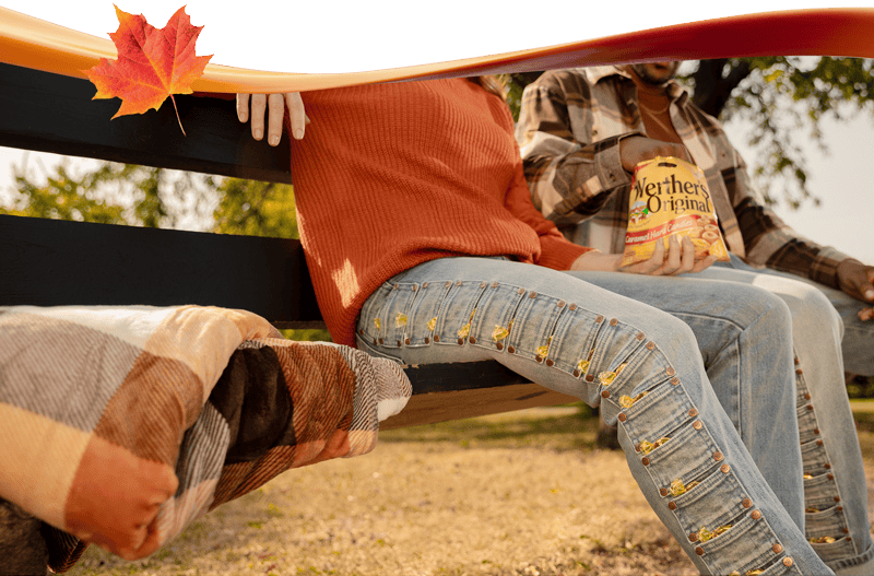 A couple sitting on a bench with Werther's Original pocket denim on